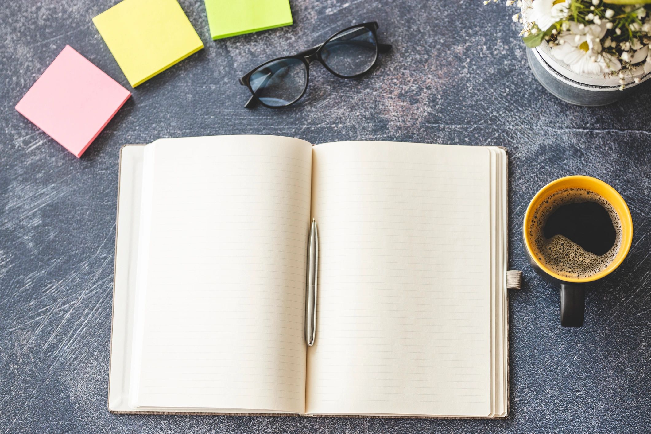 Minimal flat lay with notebook, coffee, and eyeglasses