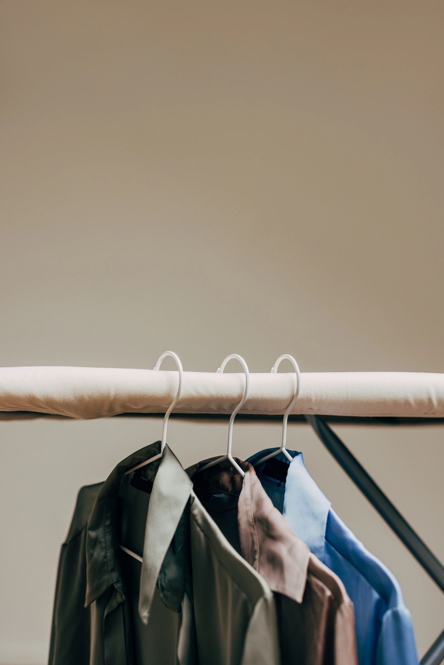 Neutral shirts hanging neatly on a rack