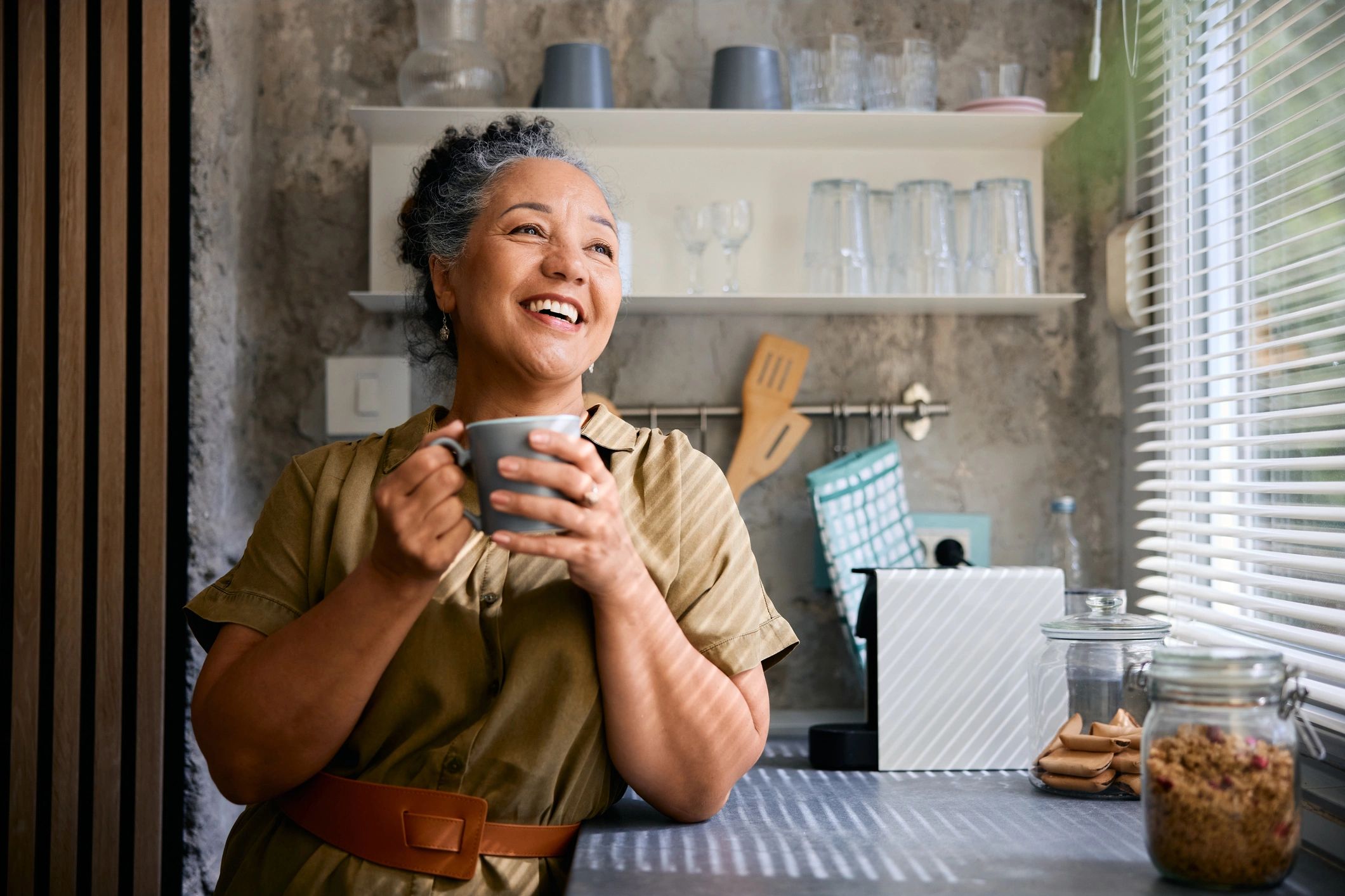 Mature woman enjoying coffee in a bright kitchen