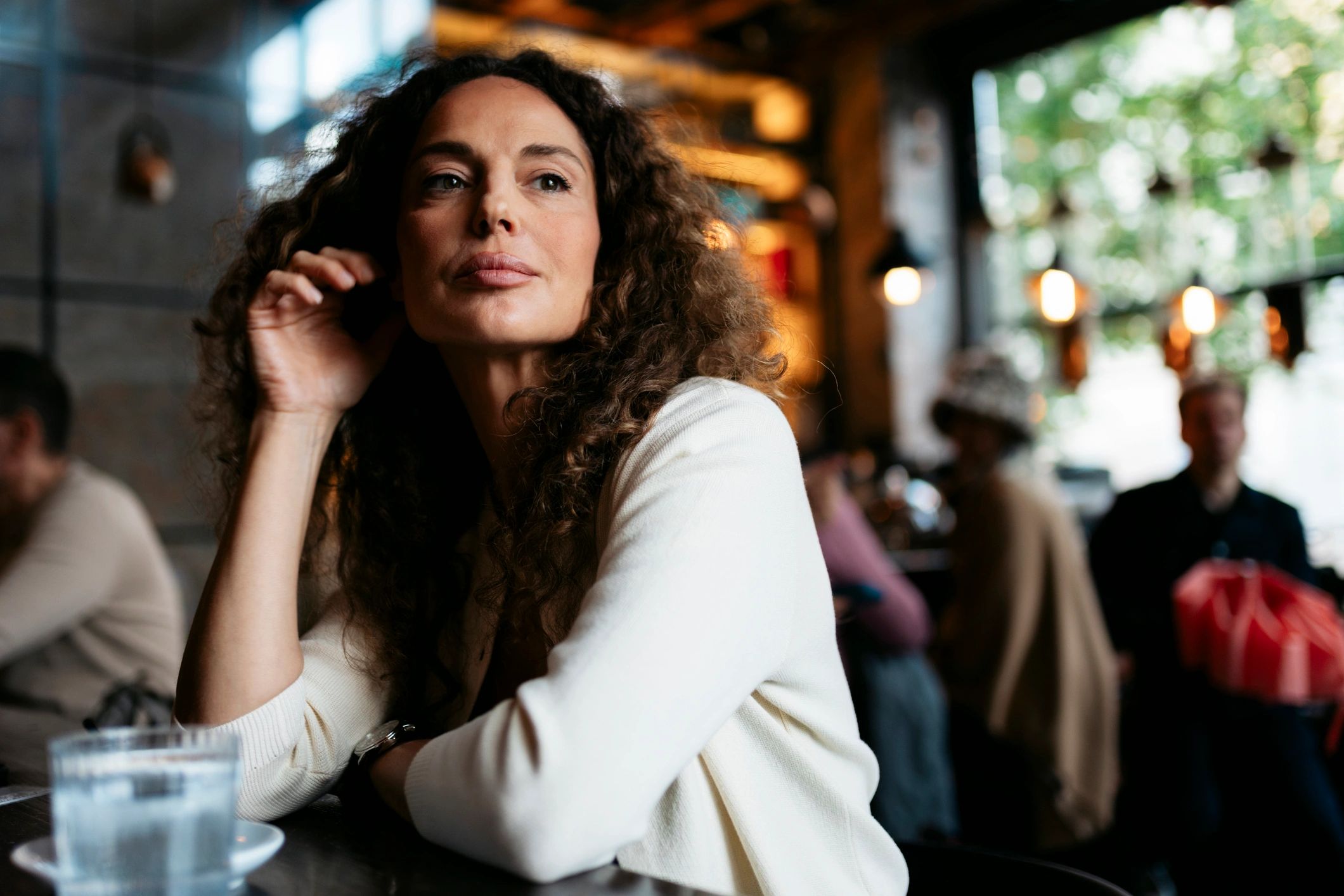 Mature woman daydreaming in a cozy cafe