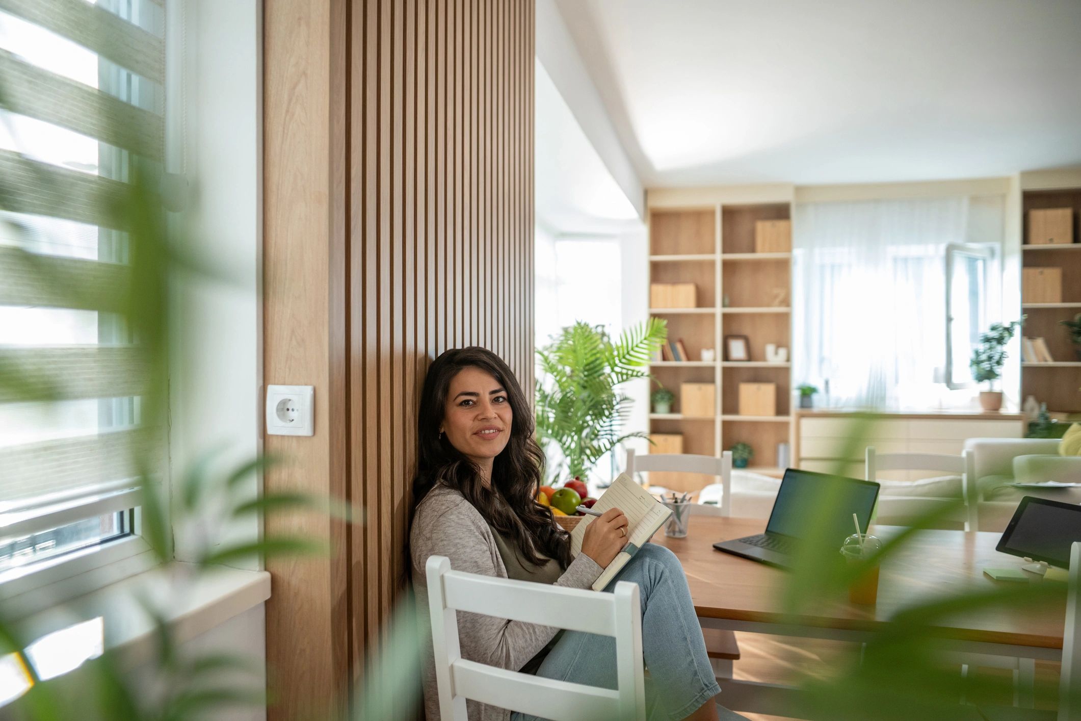 Woman journaling at a table in a bright home